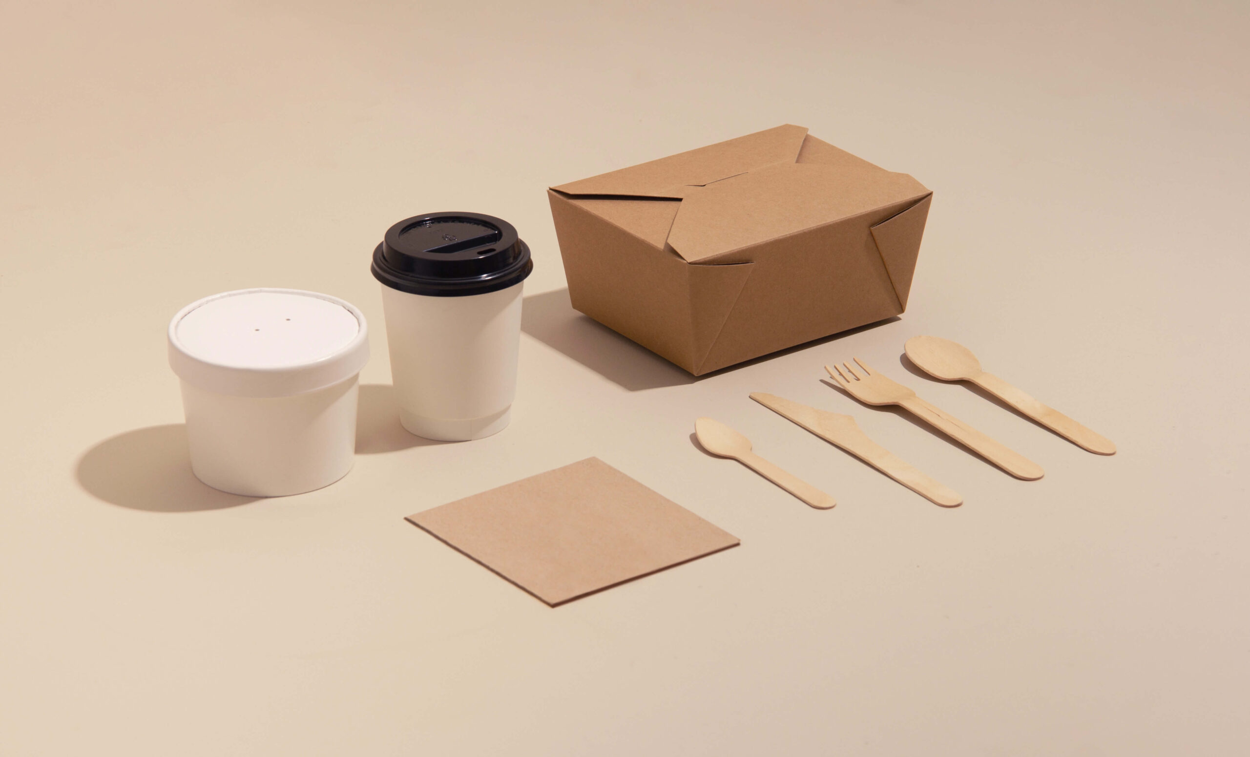 cardboard boxes in different shapes, 1 cardboard glass and wooden spoons lying on a flat surface